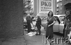 25.06.1981, Radom, Polska.
Mężczyźni wyjmujący z samochodu pudła z książkami. Na pierwszym planie widoczne są dwie kobiety palące papierosy. Na bloku namalowany został napis: 
