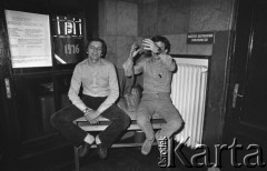 25.06.1981, Radom, Polska.
Dwaj mężczyźni siedzący na blacie stolika. Po lewej stronie widoczny jest plakat upamiętniający wydarzenia radomskie oraz informacja dotycząca Koncertu 
