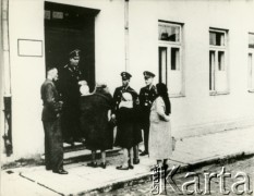 1939-1942, Płońsk, Polska.
Fotografia przedstawia funkcjonariuszy Einsatzkommando 3, przed szkołą obraną na siedzibę EK3 oraz kobiety prawdopodobnie poszukujące swoich mężów.
Fotografię wykonał funkcjonariusz Einsatzkommando 3, wchodzącego w skład Einsatzgruppe V, dowodzonej przez Ernsta Damzoga.
Fot. NN, zbiory Ośrodka KARTA, przekazał Jan Ptasiński