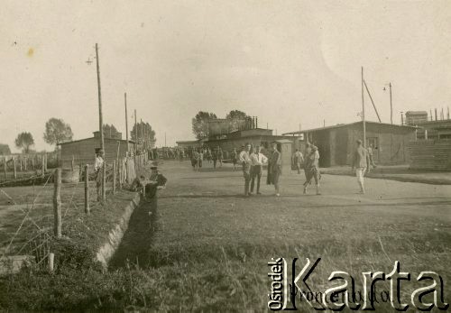 1917, Szczypiorno k/Kalisza, Polska.
Niemiecki obóz dla internowanych jeńców wojennych - polskich legionistów w Szczypiornie, żołnierze na ulicy między barakami. Na zdjęciu podpis: 