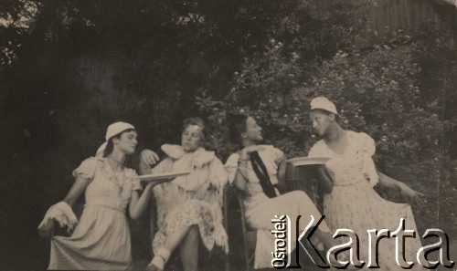 1934, brak miejsca., Polska.
Kobiety przedstawiające scenkę rodzajową, dwie siedzące w środku odgrywają damy, dwie po bokach ich służące.
Fot. NN, zbiory Ośrodka KARTA, Pogotowie Archiwalne [PAF_005], udostępnił Krzysztof Dobrecki