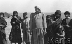 1943, Irak.
Grupa irakijskich kobiet z dziećmi, w środku stoi mężczyzna w kamizelce włożonej na galabiję.
Fot. Czesław Dobrecki, zbiory Ośrodka KARTA, Pogotowie Archiwalne [PAF_015], przekazał Krzysztof Dobrecki
