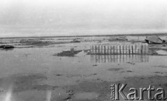 1943, Irak.
Obóz wojskowy zalany wodą, na pierwszym planie paczki, w tle namioty.
Fot. Czesław Dobrecki, zbiory Ośrodka KARTA, Pogotowie Archiwalne [PAF_015], przekazał Krzysztof Dobrecki
