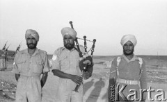 Maj 1942, Palestyna.
Trzej hinduscy żołnierze, w środku stoi kobziarz grający na kobzie.
Fot. Czesław Dobrecki, zbiory Ośrodka KARTA, Pogotowie Archiwalne [PAF_015], przekazał Krzysztof Dobrecki