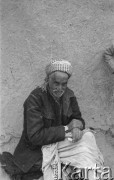 1943, Irak.
Irakijczyk trzymający dwa papierosy siedzi pod ścianą budynku.
Fot. Czesław Dobrecki, zbiory Ośrodka KARTA, Pogotowie Archiwalne [PAF_015], przekazał Krzysztof Dobrecki
