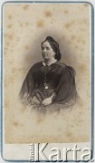 Ok.1860-1870, brak miejsca.
Portret kobiety w ciemnej sukni z szeroką spódnicą i z koronkowym szalem na ramionach.
Fot. NN, zbiory Ośrodka KARTA, udostępniła Elżbieta Sławikowska