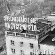 Lato 1986, Warszawa, Polska.
Ulica Świętokrzyska róg Marszałkowskiej. 
Rozwieszanie transparentu o treści: 