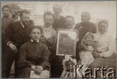 Ok. 1905, Moskwa, Rosja.
Rodzina Klukowskich przed domem. Pierwsza z lewej siedzi Zofia Borysowicz z domu Klukowska (1878-1920), za nią stoi jej mąż Konstanty Borysowicz, z tyłu (jest najwyższy) - Jordan Klukowski (1839-1921), dalej na prawo jego żona Felicja Klukowska (1846-1929), między nimi (poniżej) ich syn Julian Klukowski (1872-1917), a obok niego siedzi jego żona Eufrozyna Antonina z domu Osadcza (1879-1959). Na zdjęciu widoczne są także dzieci Juliana i Eufrozyny - siedzący na kolanach matki Jan (1904-1944) oraz jego starsza siostra Zofia (1902-1944).
Fot. NN, zbiory Ośrodka KARTA, udostępniła Joanna Majewska