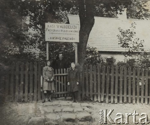 1924-1932, Kosów Poleski, woj. poleskie, Polska.
Ksiądz i dwie kobiety stojące przy tablicy w napisem: 
