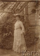 1906, Kamienna, Rosja.
Jadwiga Sznepel w jasnej sukni, w kapeluszu i z parasolką stoi oranżerii.
Fot. NN, zbiory Ośrodka Karta, udostępniła Elżbieta Bakanowska