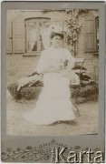 Ok. 1900, brak miejsca.
Młoda kobieta w białej sukni i kapeluszu, siedząca na ławce z psem.
Fot. NN, zbiory Ośrodka KARTA, udostępniła Agata Niewiarowska.