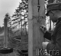 7.11.1939, Polska. Wschodnia
Niemiecko- sowiecka linia demarkacyjna, żołnierz Wehrmachtu dokonuje pamiątkowego wpisu na słupie granicznym.
Fot. Hugo Jager, zdjęcia z albumu 