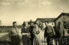 1940, Targu-Jiu, Rumunia.
Obóz dla internowanych żołnierzy Wojska Polskiego, stoją od lewej: oficer bez kurtki mundurowej; kobieta w sukience w groszki; kapitan WP w letnim mundurze służbowym, wz. 36 i w furażerce na głowie; kobieta w sukience w kwiaty; kapitan pilot Tadeusz Krajewski, dwaj żołnierze WP – szeregowi, w mundurach służbowych, jeden z nich ma na głowie furażerkę polową wz. 37, drugi furażerkę; siedzący podporucznik WP jest w mundurze służbowym wz. 36, na głowie ma furażerkę. Na odwrocie pieczątka 
