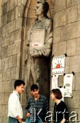Wiosna 1990, Warszawa, Polska.
Kampania wyborcza przed wyborami samorządowymi w dniu 27 maja 1990 roku. Młodzi ludzie stoją przy ścianie Pałacu Kultury i Nauki, obok wiszą plakaty wyborcze 