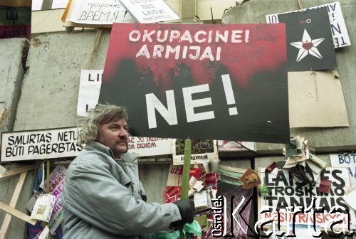 Styczeń 1991, Wilno, Litwa.
Mężczyzna z transparentem przed umocnieniami otaczającymi parlament.
Fot. Wojciech Druszcz, zbiory Ośrodka KARTA