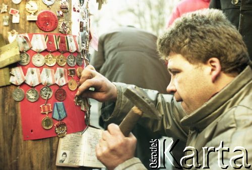 Styczeń 1991, Wilno, Litwa.
Plac przed gmachem parlamentu, mężczyzna przybija sowiecki order do drewnianego słupa.
Fot. Wojciech Druszcz, zbiory Ośrodka KARTA