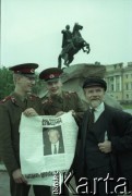 Wiosna 1991, Petersburg, Rosja.
Miasto w dniach kampanii prezydenckiej. Dwaj żołnierze trzymający plakat Borysa Jelcyna stoją obok mężczyzny będącego sobowtórem Włodzimierza Lenina. W tle pomnik Piotra I Wielkiego (tzw. Jeździec miedziany). 
Fot. Wojciech Druszcz, zbiory Ośrodka KARTA
