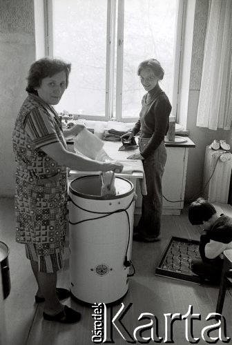 1976-1977, Polska.
Kobiety podczas prac domowych, jedna pierze druga prasuje, obok chłopiec gra w piłkarzyki.
Fot. Joanna Helander, zbiory Ośrodka KARTA
