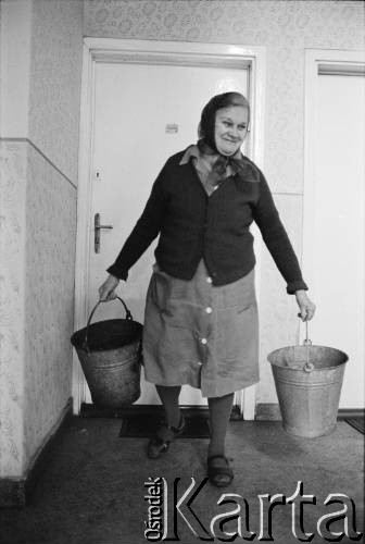 1976-1978, Ruda Śląska, woj. katowickie, Polska.
Kobieta z kubłami na śmieci przed wejściem do  mieszkania.
Fot. Joanna Helander, zbiory Ośrodka KARTA