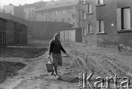 1976-1978, Ruda Śląska, woj. katowickie, Polska.
Maria Hajduga z wiadrem na śmieci przy budynku zwanym 