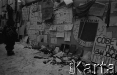 Styczeń 1991, Wilno, Litwa.
Dziecko przy umocnieniach otaczających budynek Sejmu. Na ogrodzeniu plakaty, poniżej leżą książki i broń.
Fot. Anna Pietuszko, zbiory Ośrodka KARTA
