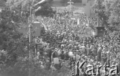 Sierpień 1980, Gdańsk, Polska.
Strajk okupacyjny w Stoczni Gdańskiej im. Lenina. Widok z góry na zgromadzonych strajkujących. Za bramą tłum ludzi, dalej widoczny drewniany krzyż upamiętniający stoczniowców poległych w grudniu 1970 roku.
Fot. Zbigniew Trybek, zbiory Ośrodka KARTA

