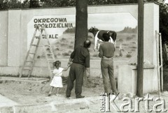 1988, Polska.

Przed reklamą Spółdzielni Okręgowej.

Fot. Jerzy Szot, zbiory Ośrodka KARTA