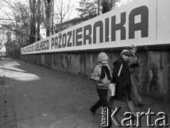 1982, Kraków, Polska.
Dzieci przechodzą obok tablicy dotyczącej rocznicy rewolucji październikowej.
Fot. Jerzy Szot, zbiory Ośrodka KARTA