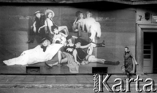 1985, Kraków, Polska
Staruszka z wiadrem przechodzi pod plakatem reklamującym damską odzież.
Fot. Jerzy Szot, zbiory Ośrodka KARTA