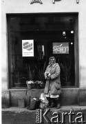 Październik 1985, Kraków, Polska
Kampania wyborcza przed wyborami do parlamentu. Kobieta handlująca kwiatami stoi przed budynkiem. W oknie wiszą plakaty z hasłami: 