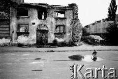1989, Kraków, Polska.
Krakowski Kazimierz - dziecko bawi się w kałuży. W tle ruiny budynku.
Fot. Jerzy Szot, zbiory Ośrodka KARTA

