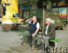 1993, Kraków, Polska.
Krakowski Kazimierz - mężczyźni piją alkohol. Za nimi magiel i reklama Lotto.
Fot. Jerzy Szot, zbiory Ośrodka KARTA
