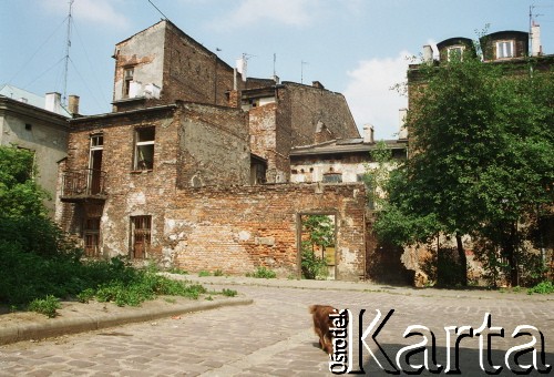1998, Kraków, Polska.
Krakowski Kazimierz - pies przechodzi brukowaną ulicą, w tle zniszczone kamienice.
Fot. Jerzy Szot, zbiory Ośrodka KARTA

