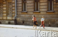 1980, Kraków, Polska.
Przechodnie na ulicy. Na murze hasła kontestujące władzę: 