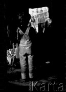 1982, Kraków, Polska.
Mały chłopie stoi prze mężczyzną czytającym 