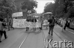 1989, Kraków, Polska
Uczestnicy demonstracji ulicznej na torowisku tramwajowym z  kukłą Wojciecha Jaruzelskiego i transparentami z hasłami 