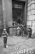1989, Kraków, Polska.
Dzieci przed sklepem z butami. Na witrynie napis 