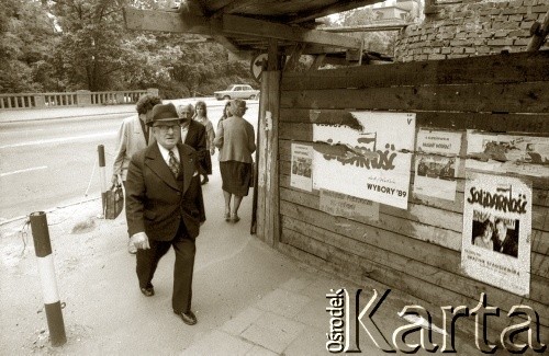 1989, Polska.
Wybory parlamentarne - przechodnie obok plakatów wyborczych NSZZ 
