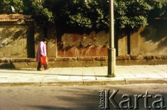 Po 1989, Kraków, Polska.
Kobieta idzie chodnikiem przy ceglanym murze.
Fot. Piotr Dylik, zbiory Ośrodka KARTA