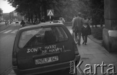 1992, Kraków, Polska.
Zaparkowany na ulicy Floriańskiej samochód na niemieckich rejestracjach. Na drzwiach bagażnika napisane hasło 