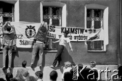 1988, Gdańsk, Polska.
Parafia pw. św. Brygidy. Mężczyźni zawieszają na budynku plebanii transparenty o treści: 