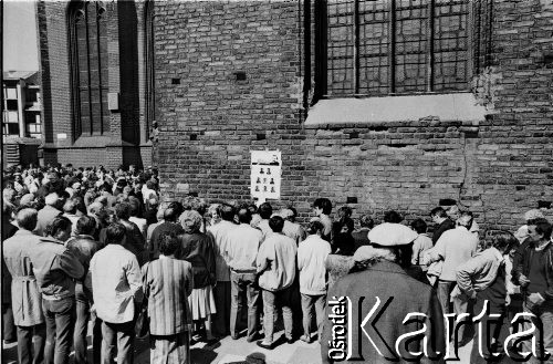 1989, Gdańsk, Polska.
Kampania przed wyborami parlamentarnymi. Tłum przy plakacie na murze kościoła pw. św. Brygidy z wizerunkami kandydatów Komitetu Obywatelskiego NSZZ 