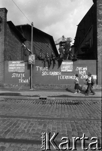 Sierpień 1980, Gdańsk, Polska.
Strajk w Stoczni Gdańskiej im. Lenina. Robotnicy siedzą na murze otaczającym stocznię. Widoczne napisy: 