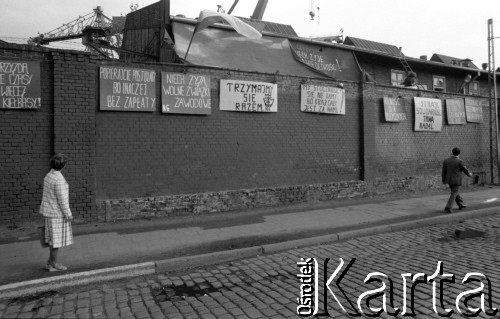 Sierpień 1980, Gdańsk, Polska.
Strajk w Stoczni Gdańskiej im. Lenina. Na murze stoczni wiszą transparenty z hasłami: 