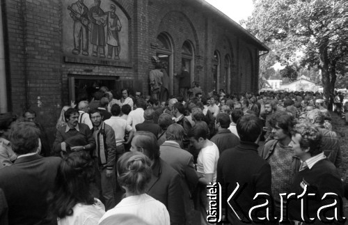 Sierpień 1980, Gdańsk, Polska.
Strajk w Stoczni Gdańskiej im. Lenina. Strajkujący przed budynkiem sali BHP. Kilku mężczyzn zagląda przez okno do środka budynku.
Fot. Witold Górka, zbiory Ośrodka KARTA