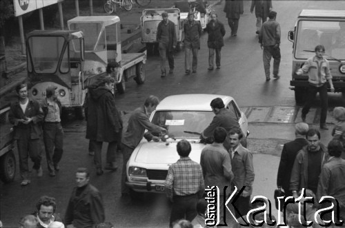 Sierpień 1980, Gdańsk, Polska.
Strajk w Stoczni Gdańskiej im. Lenina. Dwaj robotnicy ozdabiają samochód kwiatami. Na oknie samochodu kartka o treści: 