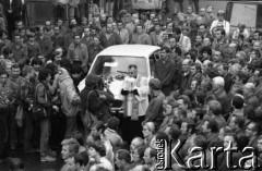 Sierpień 1980, Gdańsk, Polska.
Strajk w Stoczni Gdańskiej im. Lenina. Przy samochodzie stoi ksiądz, wokół niego fotoreporterzy i stoczniowcy.
Fot. Witold Górka, zbiory Ośrodka KARTA