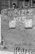 Sierpień 1980, Gdańsk, Polska.
Strajk w Stoczni Gdańskiej im. Lenina. Strajkujący oparty o mur stoczni, na którym napisano hasło 