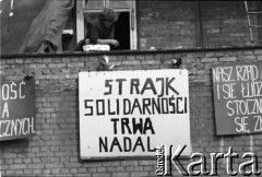 Sierpień 1980, Gdańsk, Polska.
Strajk w Stoczni Gdańskiej im. Lenina. Robotnik na murze stoczni, na którym zawieszono tablice z hasłami, m.in. 