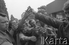 Sierpień 1980, Gdańsk, Polska.
Strajk w Stoczni Gdańskiej im. Lenina. Robotnicy przekazują sobie fotografie.
Fot. Witold Górka, zbiory Ośrodka KARTA